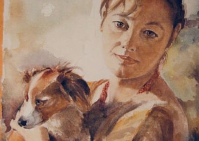 Ritratto, dai toni caldi, di una giovane donna con in braccio un cane volpino