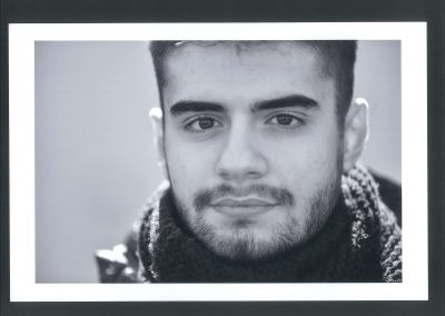 Primissimo piano bianco e nero di giovane ragazzo con barba corta
