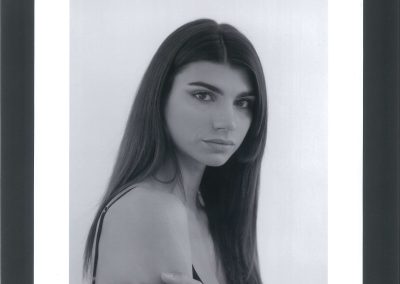 Ritratto a mezzo busto di giovane modella dai capelli lunghi e scuri