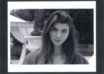 Ritratto a mezzo busto di giovane modella dai capelli lunghi e scuri