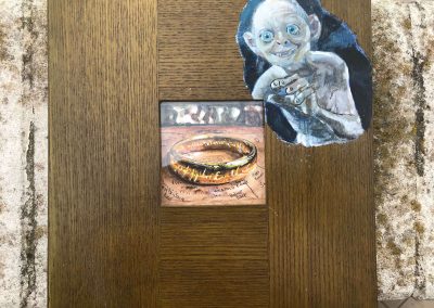 Su una cornice di legno l'immagine di Gollum che tenta di rubare l'Anello del Potere, posto al centro della cornice