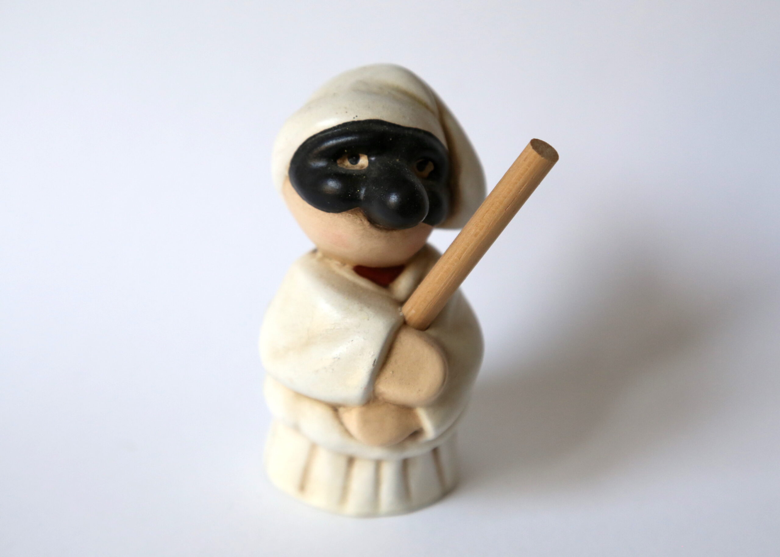 Piccolo Pulcinella di ceramica con bastone tra le mani
