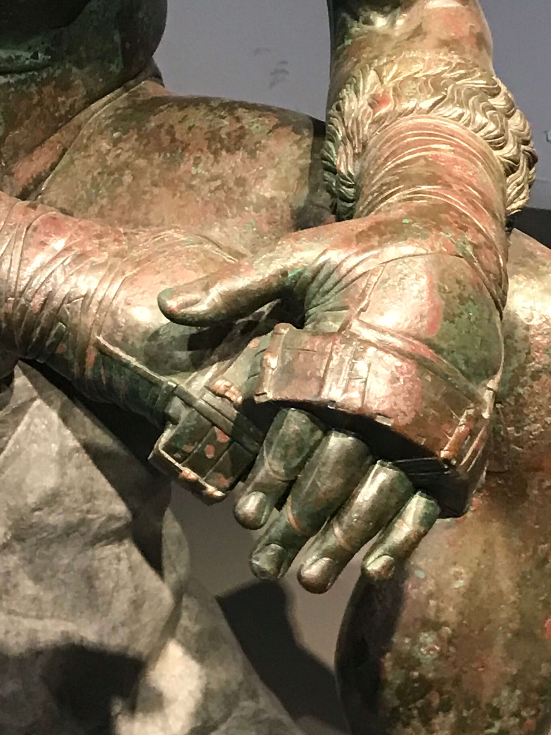 primo piano di due mani con antichi guanti da pugile romano, appoggiate una sull'altra